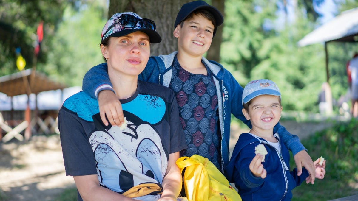 Mother with her two sons having fun outdoors, enjoying a sunny day.